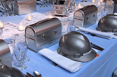 Tabletops adorned with silver hats, trucks, and lunch boxes set the scene inside the dinner tent.