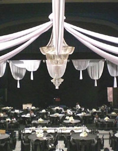 White chiffon panels, draped from the perimeter of the ceiling, met in the center of the room at Bay Stage Lighting's crystal chandeliers.