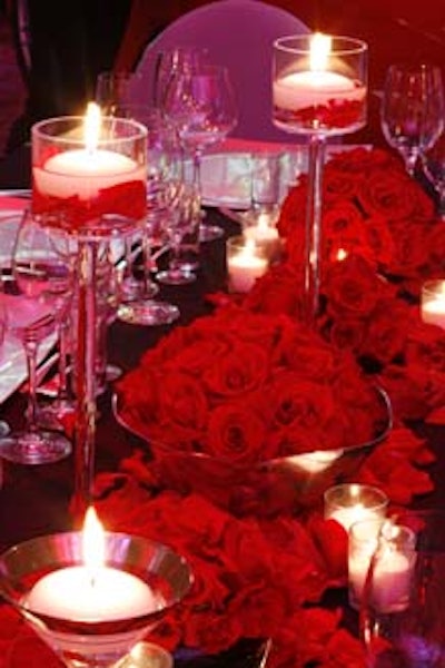 BayFront Floral Decorators created centerpieces by placing large silver bowls with red roses and rose petals that overflowed onto the table and accenting them with tea lights.