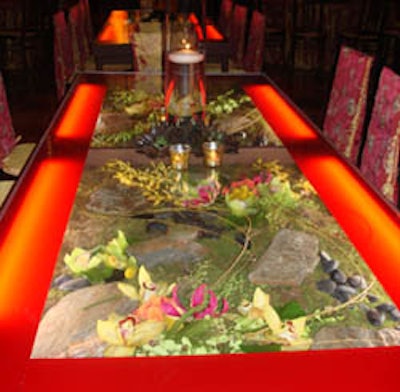 Designs by Sean created this tablescape by placing rocks, orchids, and other natural elements inside the long tables at an event at the Dupont Building in Miami