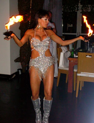 A scantily clad fire dancer mesmerized guests with her seductive dance moves and fiery display.
