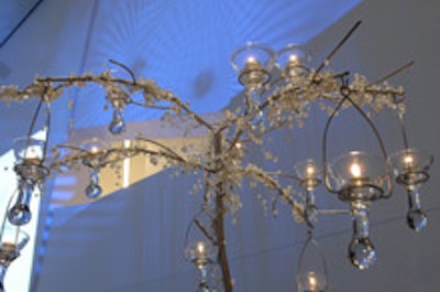 Crystal beads and tealights decorated tall tree branches.