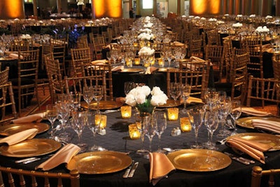 Gold table settings and rose centerpieces at the Mayor's conference gala