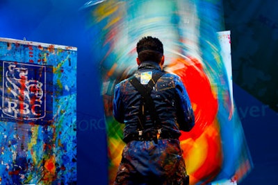 An artist paints on a rotating canvas during RBC's stage show.