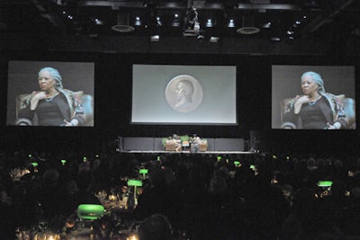 Three oversize screens broadcast the interview from the front of the space.