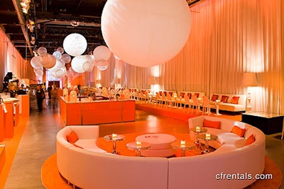 White curved lounges, orange plexiglass bars, white Moooi floor lamps, white sofas as banquettes, white Louis Ghost chairs, and lots of orange carpeting