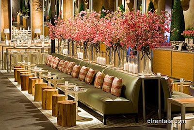 Tree-stump stools, white mirror-topped cocktail tables, lattice carpets, sage sofas, gingham cushions, natural oak bars, boxwood topiaries, and lots of flowering dogwood