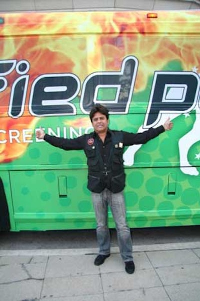 Former 'CHiPs' star Erik Estrada poses in front of the Land Yacht, used here as a mobile convention booth.