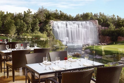 The glass-enclosed main dining room offers postcard views of the fairways and majestic 18th-hole waterfall.