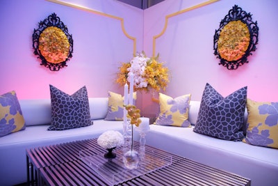 Bolster sofas are paired with the slits tables and accented with florals suspended in the air, as well as framed flower arrangements. The event was held at the trendy SLS hotel in Los Angeles, where LED lighting washed the room.