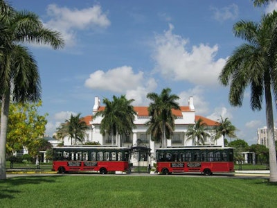 Two trolleys wait at the Flagler Museum, Palm Beach