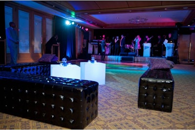 Syzygy Event Productions used tufted black ottomans, illuminated cube tables, and small plasma globes.