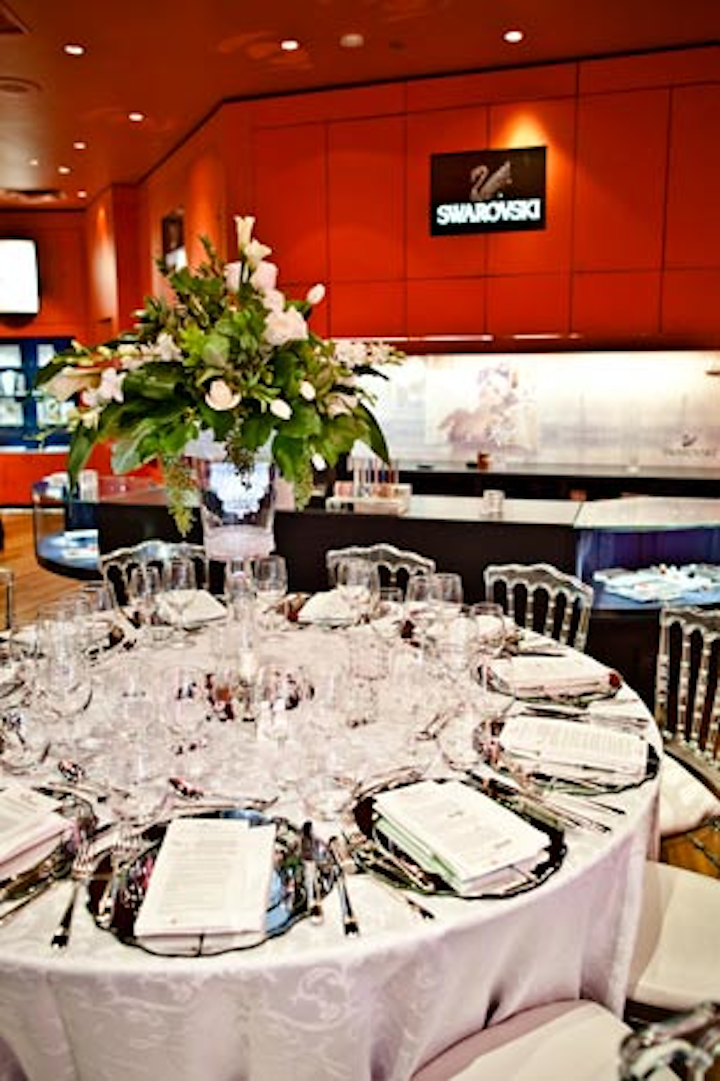 At Swarovski, miniature chandeliers hung underneath the floral arrangements. Tables were set with mirrored charger plates.