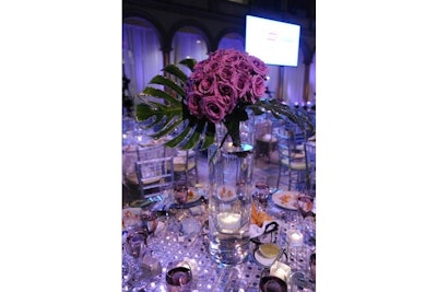 Amaryllis filled oversize glass vases with purple roses and fronds edged in glitter.