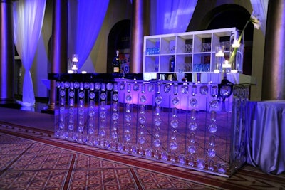 The reception area included mirrored and sleek white bars, as well as Lucite accents like clear tables with large floral arrangements inside.