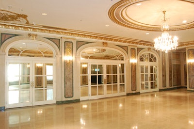 The grand ballroom foyer is decorated with mirrors, elaborate detailing, and polished floors; it opens directly onto the ballroom.