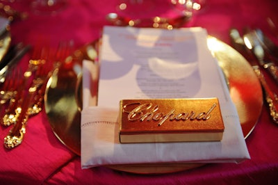Gold boxes emblazoned with rhinestone Chopard logos containing Chopard pens sat on tabletops.