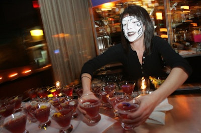 A server in a makeup mask served the night's signature cocktail, a lavender orchid martini with edible flowers.