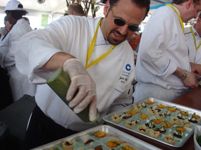 Inside the American Express Grand Tasting Tents, a chef from Centerplate Catering put the finishing touches on a tasty trio of hors d'oeuvres.