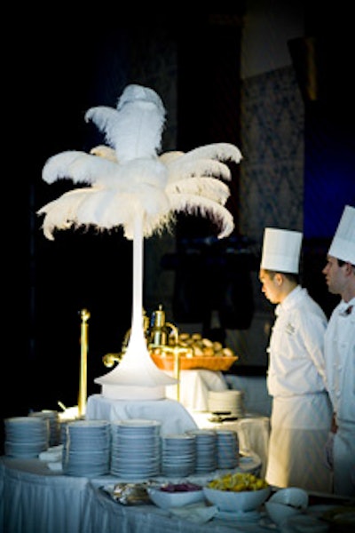 A feathered palm tree decorated a food station where hotel staff served pastrami and smoked salmon sandwiches.