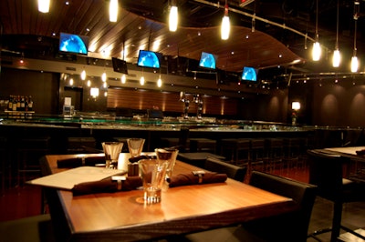 A rippled wood slat ceiling defines the bar area.
