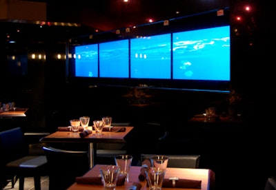 A granite wall with flowing images on four screens set beneath smoked glass provides a focal point at the back of the dining room.