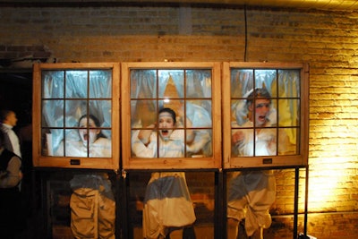 Redmoon performers pulled faces behind window panes as part of the evening's ongoing surprises.