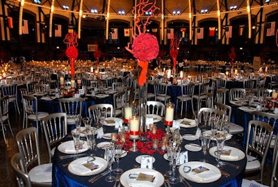 A Perfect Event dressed dinner tables with blue silk linens and vases holding rose spheres and red-lacquered manzanita branches meant to resemble coral.