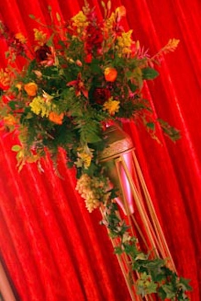 Large bronze vases were filled with red, purple, and orange roses.