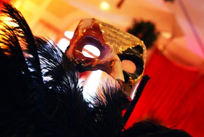 Large black ostrich feather centerpieces featuring Venetian-style masks decorated each table.