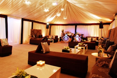 Covered banquettes and sofas, white parsons coffee tables, billowing white fabric and baroque end tables added to the luxe atmosphere inside the tent.