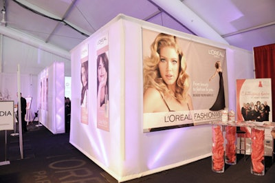 A series of L'Oréal posters hang on the exterior walls of the media lounge inside the main tent.