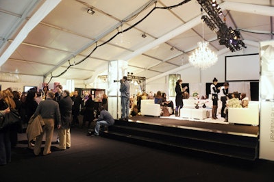 Centre Court—an elevated lounge area in the middle of the main tent—features a large white sectional sofa, white ottomans, and white-topped tables courtesy of Luxe Rentals.