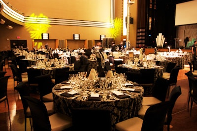 Designer Sinclair Russell topped dining tables with a grey-and-black damask fabric, with mosaic-tiled busts and fashionable shoes serving as centrepieces.