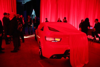 As the car wasn't debuting until the next morning, the Kia team wanted to give the press at the event a sneak peek without giving the game away, placing the partially covered red vehicle in a room washed with vibrant red lighting.