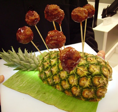 Homemade 'meatball lollipops' on bamboo skewers, accompanied by barbecue sauce, were arranged in a halved pineapple for guests to pluck.