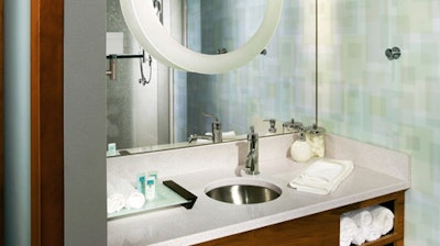 Tiled walls in the SpringHill Suites bathrooms complement the brand's airy color scheme.