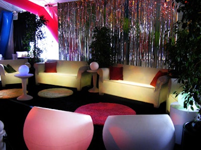 White lounge furniture uplit in colorful hues provided guests with areas to relax at the after-party.