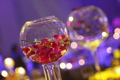 Exquisite Design Studio created centerpieces of glass globes (balanced on tall cylinders) that showed off magenta orchids.