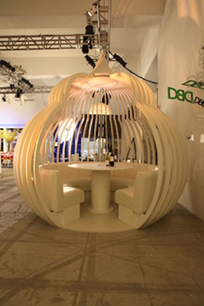 Hewlett-Packard's podlike structure, inspired by Vivienne Tam, had a minimalist look containing only a circular white table and banquette. Slatted walls enclosed the space but gave it an open feel.