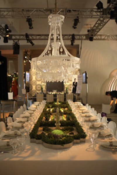 For sponsor Domino, Allison Sarofim and Stuart Parr created a miniature French garden reminiscent of Versailles that served as a living table runner. Two elaborate paper chandeliers hung above the table.