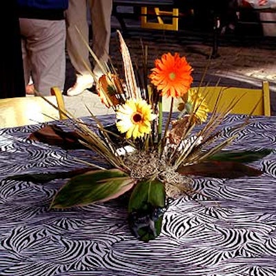 The simple arrangements of gerbera daisies and jungle-like foliage by Musters & Company and Match Catering and Eventstyles included small plastic animals.