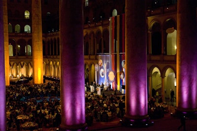 The evening's colors, purple and gold, shone on the venue's towering columns.