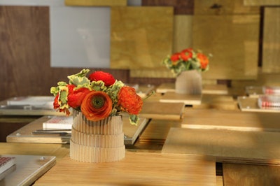 Students from Pratt Institute created their own containers by transforming humble sheets of cardboard into spiral-shaped vases. As another way of reusing materials in a new way, the designers covered the table with plywood squares, making a unique multilevel surface.