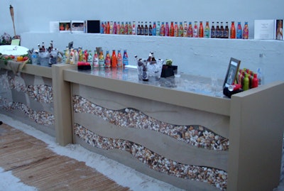 Deco Productions provided a glass bar filled with layers of sand and seashells to the summer space.