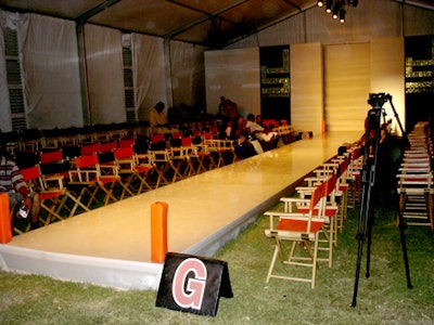 The runway was set up on a grassy area with goalposts on both ends and director's chairs of orange and black lining each side.
