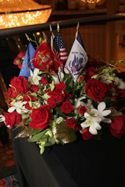 The tables included a mix of floral centerpieces (red roses and orchids pictured here), with miniature flags from each military branch.