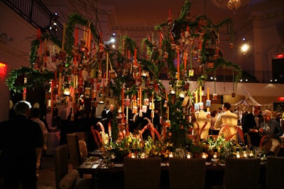 Flowers, Sticks, and Stones' interpretation of a tree featured seed packets on strands of ribbon, hanging lanterns, and birdhouses. Colorful foliage covered the base of the tree, extending along the banquet table.