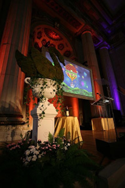 Moss-covered swan topiaries in Italian urn pedestals flanked the Mellon Auditorium stage.