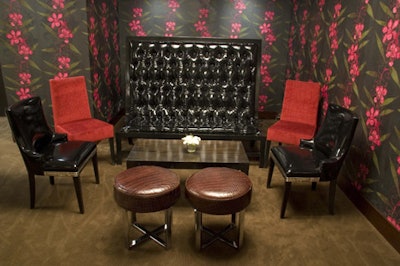 In the back, near the DJ booth, a high-backed sofa contrasts the wild-orchid-patterned wallpaper.